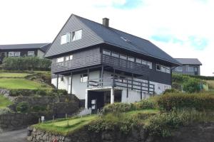托尔斯港FaroeGuide seaview villa and apartment的山顶上的大房子