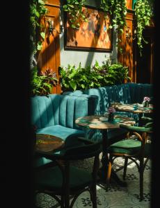 都拉斯Hotel Epidamn Boutique & Spa的一间设有桌椅的餐厅,种植了植物