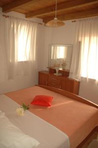 萨度拉德Apartment Vukorep的一间卧室配有一张带镜子和红色枕头的床