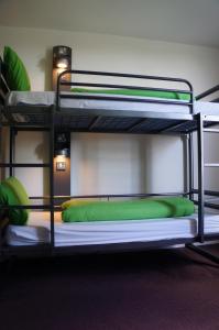康威YHA康威酒店的双层床的下铺配有绿色枕头
