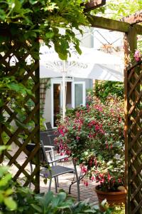 施特雷利茨Hotel Garni Schlossgarten的花园内带椅子和鲜花的庭院