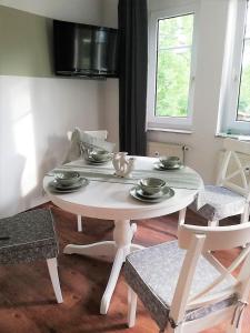巴德克洛斯特尔劳斯尼茨Ferienwohnung Am Kurpark的客厅配有白色的桌椅