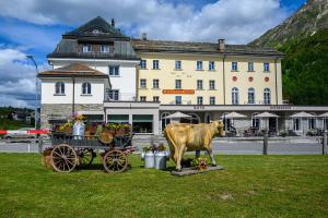 马洛亚Maloja Kulm Hotel的一座大楼前的牛和马车雕像