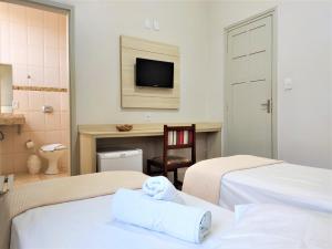 雅博蒂卡巴尔Hotel Municipal的酒店客房设有两张床和电视。