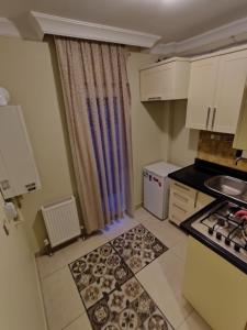 安卡拉CONCEPT HoUSE的小厨房配有白色橱柜和炉灶。