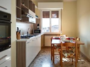 摩德纳Casa Bignardi - Affitti Brevi Italia的带小桌子的厨房和带白色橱柜的厨房