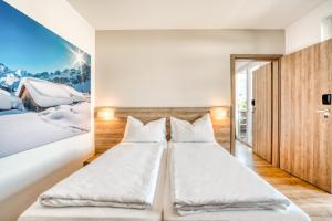 蒂罗尔州圣约翰COOEE alpin Hotel Kitzbüheler Alpen的墙上画画的房间里设有两张床