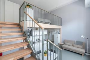 维也纳Vorgarten Apartments - central, new and stylish for your comfortable stay in Vienna的带沙发的客厅内的螺旋楼梯