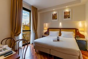 佛罗伦萨B&B Hotel Firenze Pitti Palace al Ponte Vecchio的配有一张床、一张书桌和一扇窗户的酒店客房