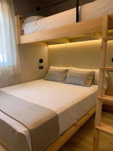 拉马丽娜拉马丽娜度假村的一间卧室配有带白色床单和枕头的双层床