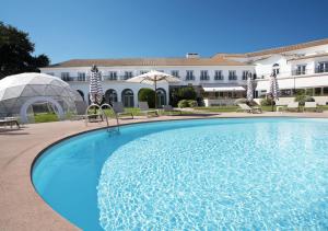 维塞乌Montebelo Principe Perfeito Viseu Garden Hotel的大楼前的大型游泳池