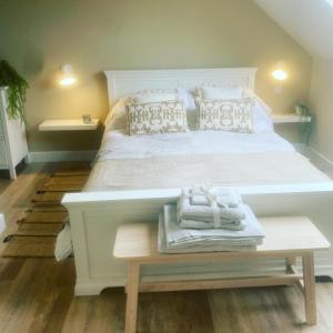 KelsallNettleford的卧室配有一张白色大床,桌子上配有毛巾