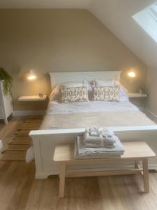 KelsallNettleford的卧室配有一张白色的大床和一张桌子