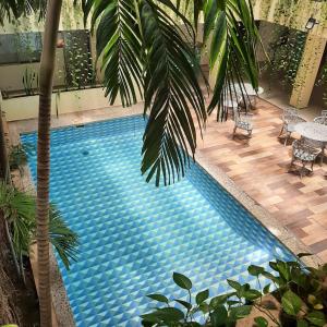 韦拉克鲁斯Grand Hotel KYRIOS Veracruz的旁边是一座棕榈树的大型游泳池