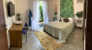 维多利亚Guesthouse Mata da Praia的一间卧室设有一张床、一台电视和一个窗口。