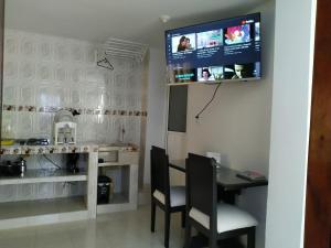卡利Apartamento oasis del norte的厨房配有桌子,墙上配有电视。