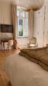 隆勒索涅L'APPARTEMENT by Merveilles de Marie的卧室配有床、椅子和窗户。