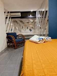 加拉加斯Hotel Renovación的一间卧室配有一张带椅子和床罩的床