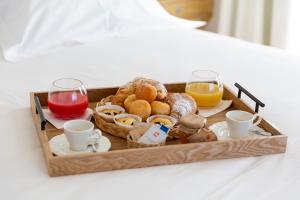 佩斯卡塞罗利Relais Chalons d’Orange的床上的早餐食品和饮料托盘