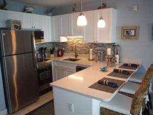 East EndLuxury Sapphire Beach Resort and Marina 1BR VII的厨房配有不锈钢冰箱和白色橱柜