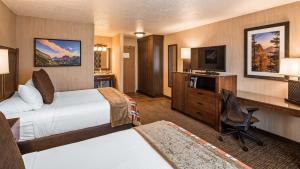 卡利斯佩尔平头湖贝斯特韦斯特套房酒店的酒店客房设有两张床、一张桌子和一台电视。