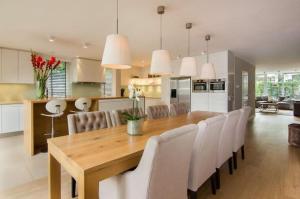 赞德沃特Time Out Beach House的厨房以及带木桌和椅子的用餐室。