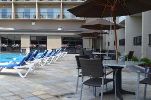 基洛纳卡普里海岸酒店 的游泳池旁一排桌椅和遮阳伞