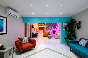 奥拉涅斯塔德Victoria City Hotel的客厅设有蓝色和橙色的椅子和楼梯