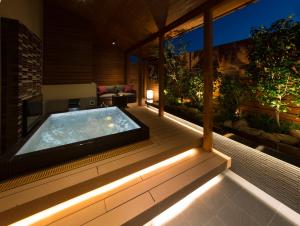 GinanHOTEL SWEET SEASON-L的房屋甲板上的热水浴池