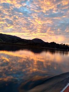 El EncanoCabañas de descanso, arcoiris del lago 1的日落在水体中的反射