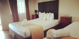 麦凯乡村广场汽车旅馆的酒店客房,配有两张床和椅子