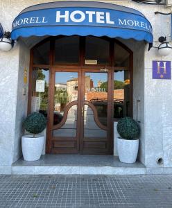 厄尔·莫雷尔HOTEL MORELL的门前有两棵盆栽植物的酒店的门