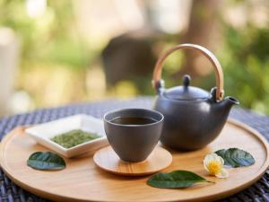 小松市Yukai Resort Premium Awazu Grand Hotel的木托盘上的茶和茶壶