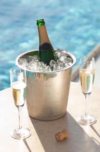 理查兹湾Premier Splendid Inn Bayshore的两杯旁冰桶里的一瓶香槟