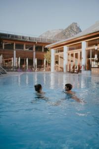 巴特奥塞G'sund & Natur Hotel Die Wasnerin - Adults Only的两个人在游泳池游泳