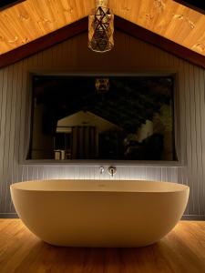 丹马克William Bay Cottages的浴室配有浴缸及镜子