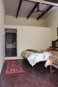 瓦拉纳西Mother Hostel的一间卧室设有两张床、地毯和窗户。