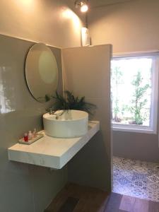 象岛Saffron On The Sea Resort的一间带水槽和镜子的浴室以及窗户。