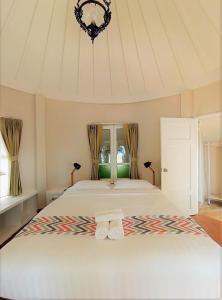 象岛Saffron On The Sea Resort的一间卧室配有一张大床和两条毛巾