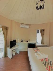 象岛Saffron On The Sea Resort的一间卧室配有一张床、一张书桌和一台电视