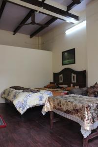瓦拉纳西Mother Hostel的客房设有两张床和一台墙上的电视。
