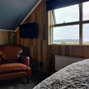 维克Prestshús 2 Guesthouse的卧室配有床、椅子和窗户。