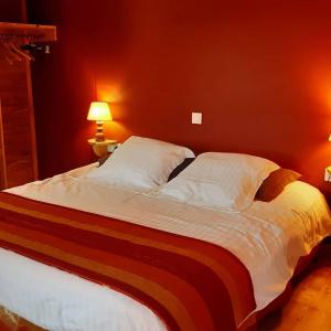Augne兰琪湖酒店的卧室内的一张大床,卧室内有红色的墙壁