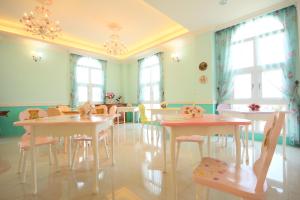礁溪蝶古巴特风情画手作民宿的用餐室设有桌椅和窗户。