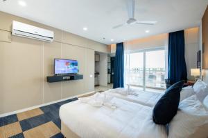 浦那StayBird - B Suite, Business Hotel, Kharadi的酒店客房设有两张床和电视。