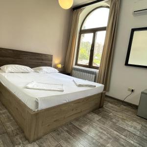 埃里温城市中心酒店的一间卧室设有一张大床和一个窗户。