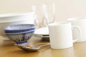 东京FLEXSTAY 白金旅馆的一张桌子,上面放着两个碗和一个白杯子