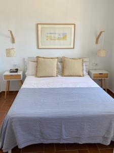 埃斯·梅卡达尔La Terraza de la Sabina的一张大白色的床,位于带两张桌子的房间