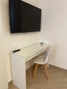 特拉帕尼Casa AnnaBella的一张白色的桌子,墙上有电视
