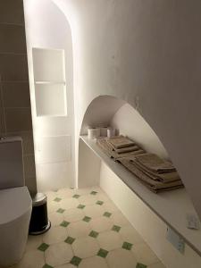 埃武拉Casa do Menino Jesus的一间带卫生间的浴室和一个带毛巾的架子